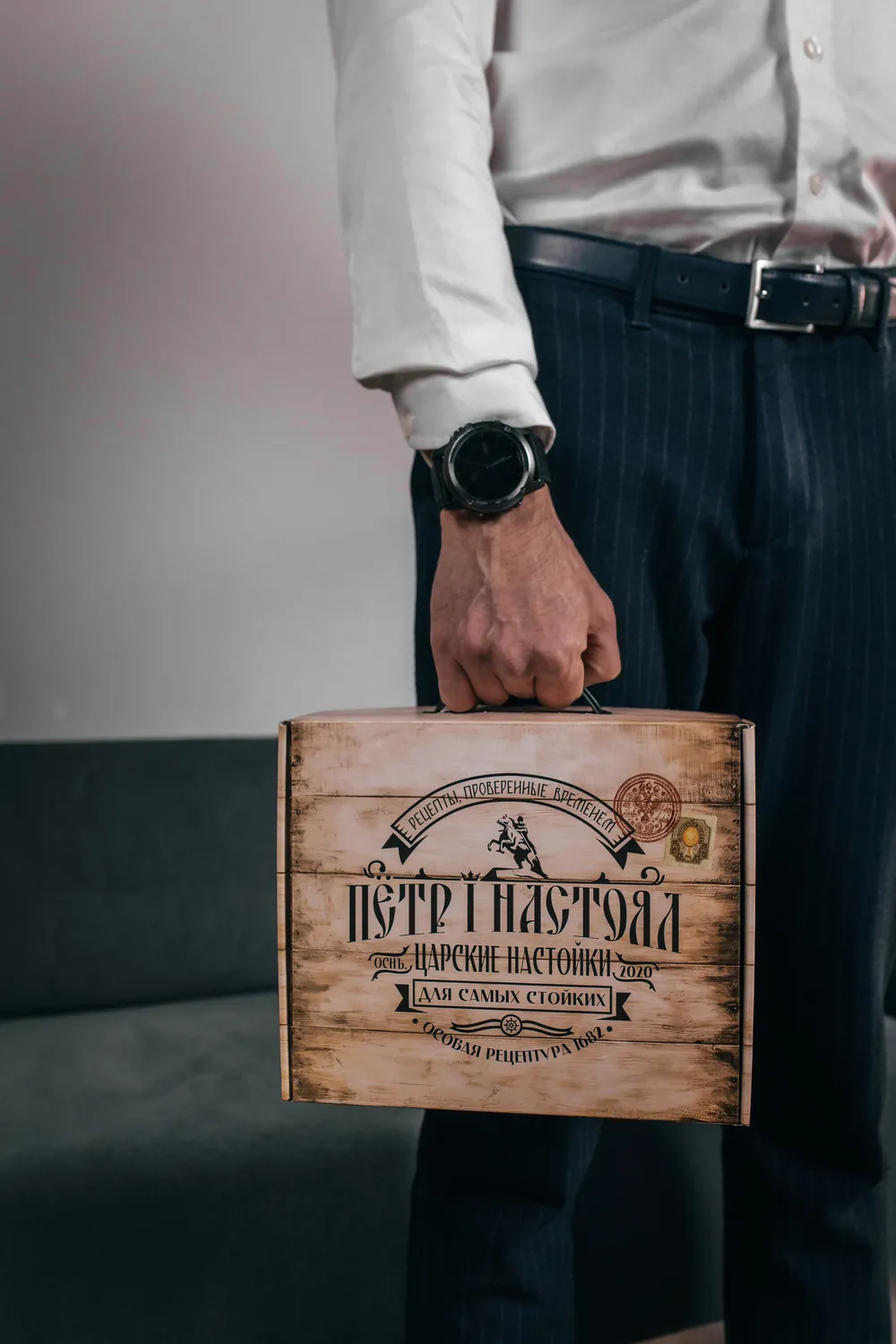 Мужчина держит подарочную коробку «Пётр I Настоял»